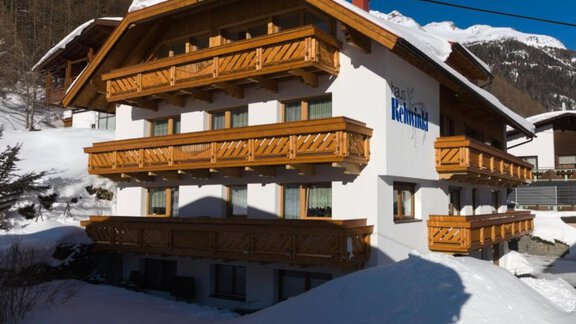 A cozy chalet in the snow with wooden balustrades and a clear blue sky. The surroundings are wintry and inviting. - Haus Rehwinkl - Sölden