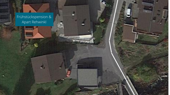 An aerial shot of a residential area with several houses. The parking lot is clearly marked, and there is a sign for the bed and breakfast and Apart Rehwinkl. - Haus Rehwinkl - Sölden