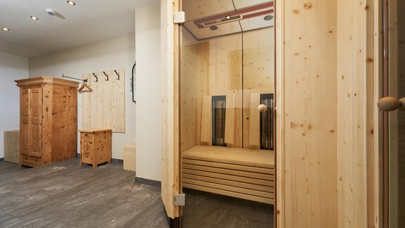 A modern wooden sauna with a clear, cozy interior. Wooden cabinets are available in the background. - Hotel am Hof - Sölden