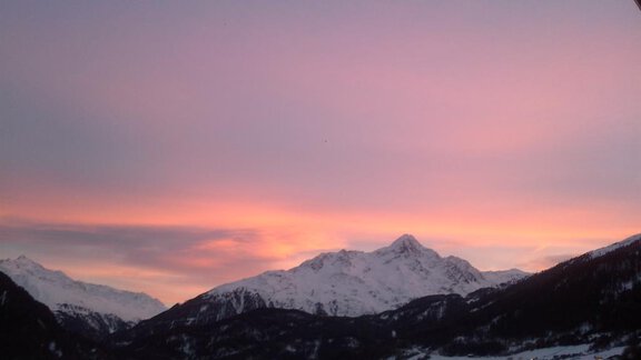 Ein atemberaubender Sonnenuntergang über schneebedeckten Bergen. Der Himmel leuchtet in sanften Rosa- und Orangetönen. - La Luna - Sölden