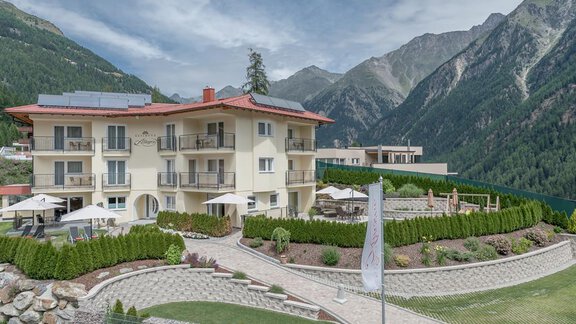 A modern building in the mountains with a well-kept garden. The surroundings are surrounded by impressive mountains and provide a peaceful atmosphere. - Residenz Allegra - Sölden | © Residenz Allegra Sölden