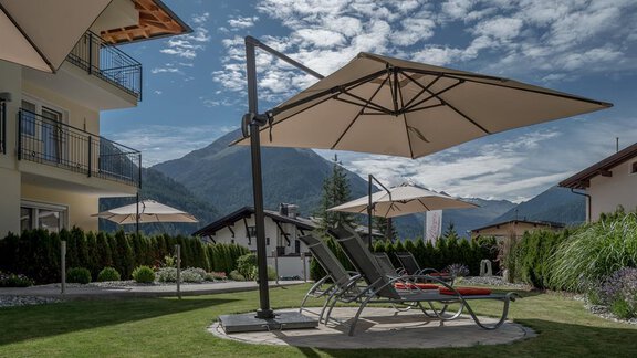 A beautiful garden with lounge chairs and sun umbrellas. In the background, mountains and a clear sky can be seen. - Residenz Allegra - Sölden | © Residenz Allegra Sölden
