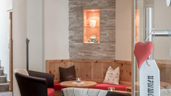 An inviting reception area with cozy armchairs and warm lighting. The wooden details and decorative elements create a harmonious atmosphere. - Residenz Allegra - Sölden | © Residenz Allegra Sölden