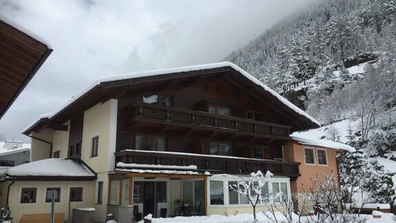 A cozy building in the snow with a mountain in the background. The sky is cloudy and it is a quiet winter landscape. - Sportpension Rubin - Sölden