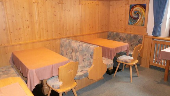 A cozy restaurant area with wooden walls and tablecloths. The tables are well arranged to create an inviting atmosphere. - Haus Riml Josef - Zwieselstein