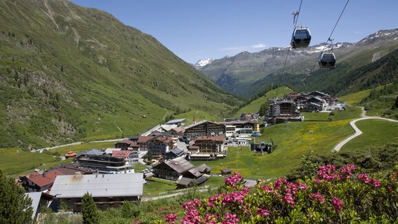 A picturesque mountain village surrounded by green meadows and high mountains. Cable cars glide over the landscape while colorful flowers bloom. - Haus Christophorus - Obergurgl 