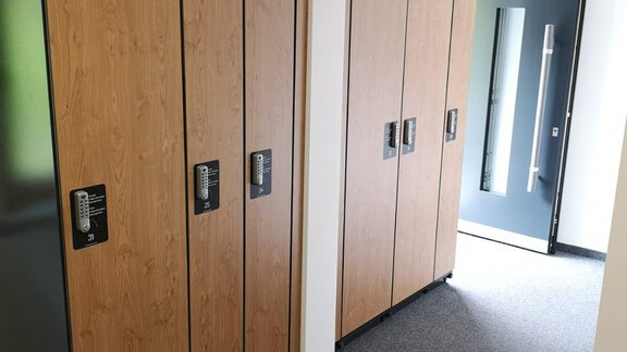A series of modern lockers made of wood and metal is located in a hallway-like room. The entrance is visible through a large, elegant door. - Haus Christophorus - Obergurgl 