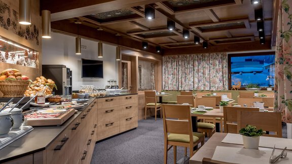 An inviting breakfast room with wooden shelves and plenty of seating. Fresh rolls and drinks are available at a buffet. - Apart Hotel Garni Wieser - Sölden