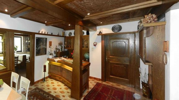 A cozy room with wood paneling and rustic decor. In the foreground, there is a wooden bar and a red carpet. - Apart Hotel Garni Wieser - Sölden