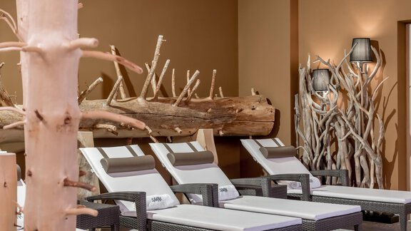 A relaxing wellness area with comfortable loungers and decorative wooden details. The warm color scheme creates a cozy atmosphere. - Apart Hotel Garni Wieser - Sölden