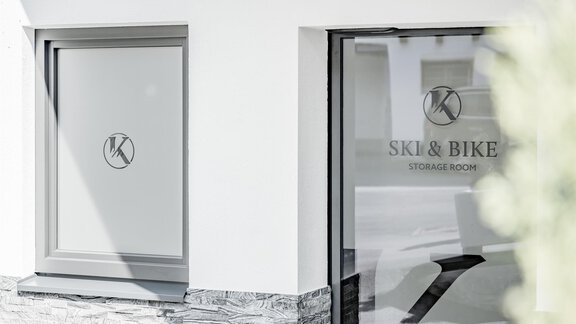 A modern room for storing skis and bicycles. The windows feature an elegant design with the logo. - Appartementhaus Kathrin - Sölden