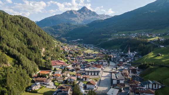 A picturesque mountain landscape with a small village in the valley. The surroundings are green and characterized by majestic mountains. - Appt. Ideal - Sölden