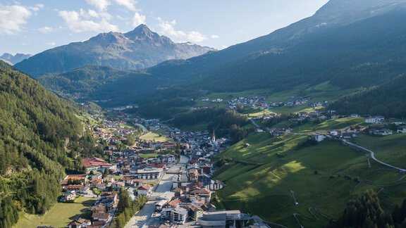 A picturesque mountain landscape with a small town in the valley. Gentle hills and impressive mountains surround the scene. - Appt. Ideal - Sölden