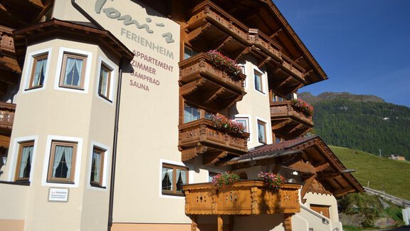 A charming vacation home with wooden cladding and blooming balconies. The mountains in the background enhance the idyllic atmosphere. - Toni's Ferienheim - Sölden