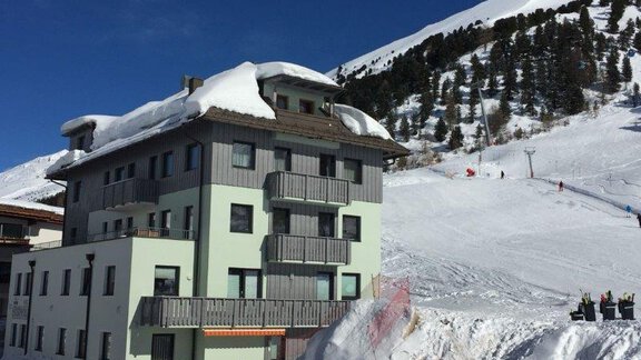 A modern building in the mountains, surrounded by snow. In the background, slopes and forests are visible. - Haus Christophorus - Obergurgl 
