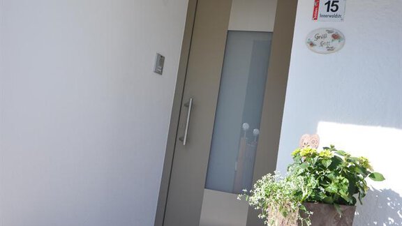 An inviting entrance with a modern door and blooming plants. The area appears friendly and well-kept. - Appartement Harmonie - Sölden