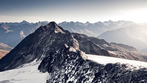 An impressive mountain landscape with rugged peaks and snow-covered areas. The sky is clear and showcases the beauty of nature. - Appartement Harmonie - Sölden
