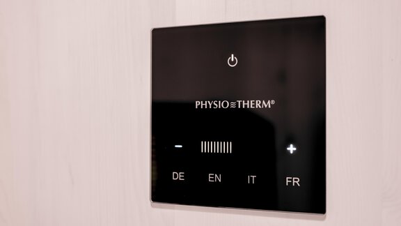 A modern control screen with buttons for different languages. It displays the "PHYSIO THERM" logo and features a power button as well as knobs. - Appartementhaus Kathrin - Sölden