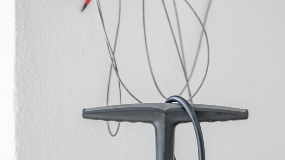 A bicycle pump is in front of a wall with a tool rack. Red pliers and wires are attached to the wall. - Appartementhaus Kathrin - Sölden