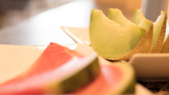 A plate with fresh pieces of melon, including watermelon and cantaloupe. The colors are bright and appetizing. - Haus Gondelblick - Sölden | © Falkner Georg