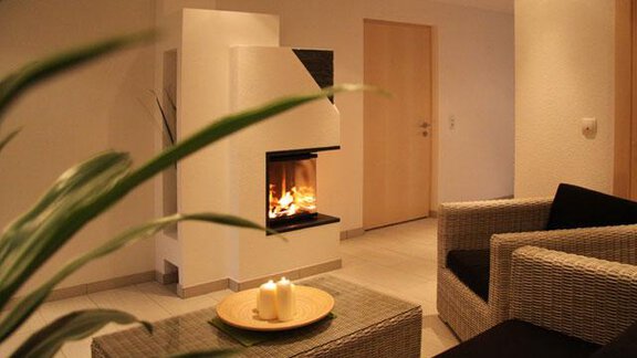 A cozy living space with a modern fireplace and comfortable furniture. Soft lighting and plants create an inviting atmosphere. - Haus Ingrid - Sölden