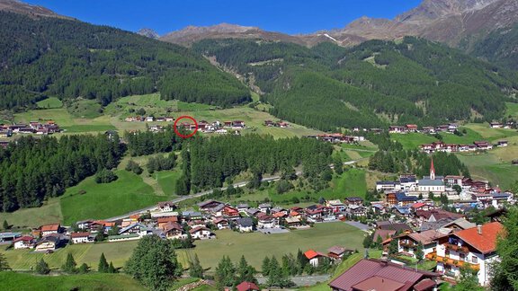 A picturesque mountain landscape with green meadows and forests. In the foreground, a peaceful village with traditional houses. - Pension Klaus - Sölden
