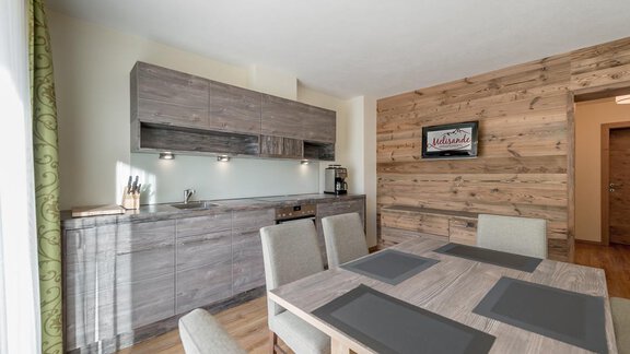 Modern kitchen with wood look and a dining table. Bright colors and elegant design create a cozy atmosphere. - The Peak Sölden - Sölden