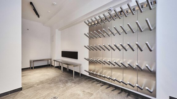 A modern room with a stylish coat rack and two tables. The walls are in neutral colors, and the floor is made of dark stone. - The Peak Sölden - Sölden