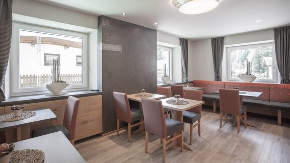 A modern and bright restaurant with stylishly furnished tables and chairs. Large windows provide plenty of daylight and an inviting atmosphere. - Garni Ötztal ROOMS & APARTS - Zwieselstein