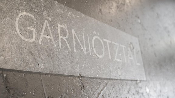A sign with the inscription "GARNIÖTZTAL". The background is made of concrete and has a simple, modern aesthetic. - Garni Ötztal ROOMS & APARTS - Zwieselstein