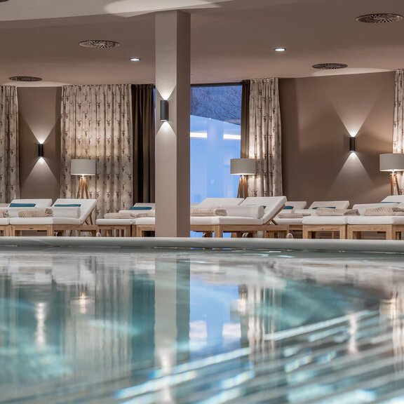 Ein eleganter Innenraum mit bequemen Liegen und einem ruhigen Schwimmbecken. Große Fenster lassen natürliches Licht herein und schaffen eine entspannende Atmosphäre. - AQUA DOME - Tirol Therme Längenfeld - Längenfeld