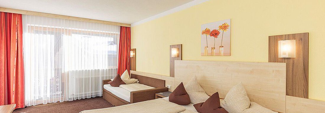 Mehrbettzimmer2 A cozy hotel room with two beds and bright colors. Large windows provide plenty of daylight and a friendly atmosphere. - Berghof Schöpf - Gries