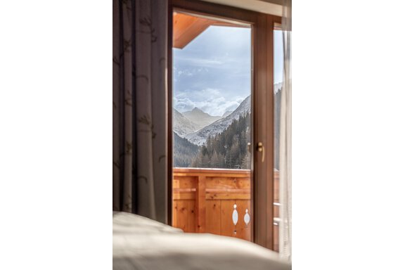 Blick aus einem Fenster auf Berge und Wiesen. Die Landschaft ist von einer ruhigen Atmosphäre geprägt und zeigt eine Mischung aus Schnee und Grün. - Hotel Schöpf - Gries