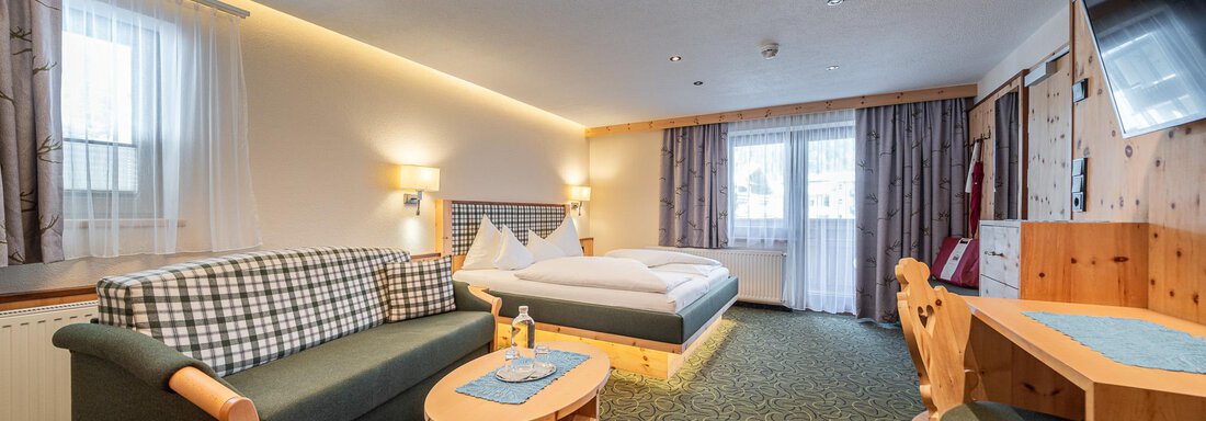 Ein komfortables Hotelzimmer mit einem Bett, einem Sofa und einem kleinen Tisch. Die Räume sind hell und freundlich eingerichtet. - Hotel Schöpf - Gries