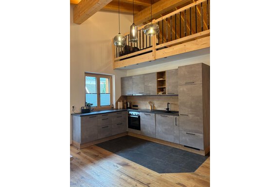 Modern kitchen with an elegant wood and stone look. Bright windows provide ample daylight in the room. - KLAMMERHOF - Gries