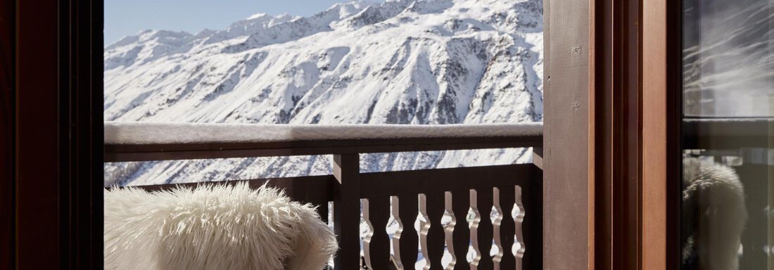 Panorama Suite Mountain View | © TOP Hotel Hochgurgl (CC C) Ein schöner Balkon mit einem gemütlichen Stuhl und einer Aussicht auf schneebedeckte Berge. Der klare Himmel strahlt eine ruhige Winteratmosphäre aus. - TOP Hotel Hochgurgl - Hochgurgl