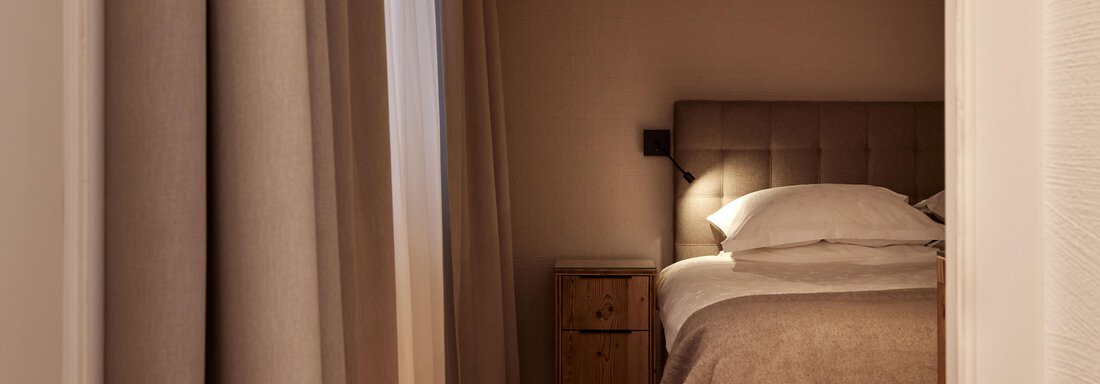 Junior Suite Sauna Ein gemütliches Schlafzimmer mit einem großen Bett und sanften Beleuchtung. Die Wände sind neutral gehalten, und Vorhänge sorgen für eine ruhige Atmosphäre. - TOP Hotel Hochgurgl - Hochgurgl