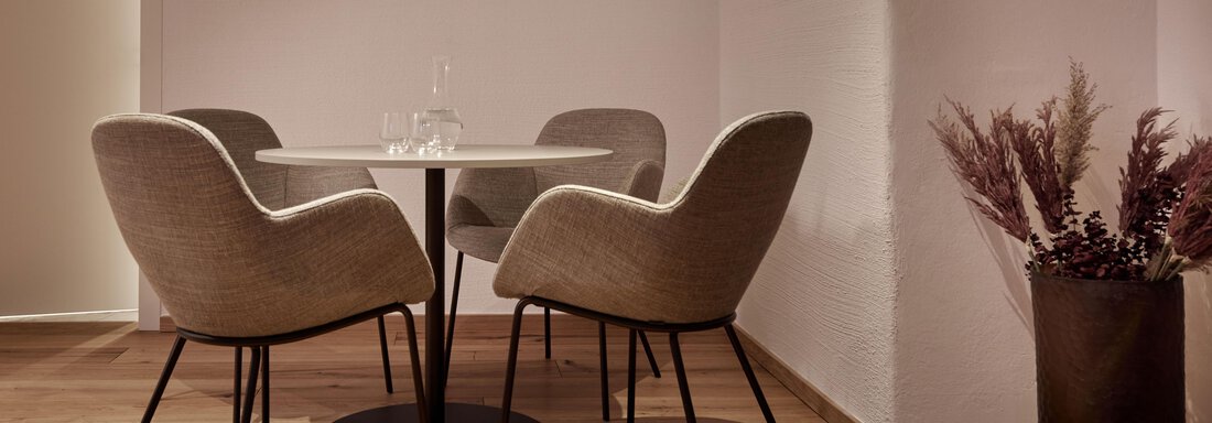 Ein stilvoller Essbereich mit vier modernen Stühlen und einem runden Tisch. Eine Pflanze in einem Topf ergänzt die gemütliche Atmosphäre. - TOP Hotel Hochgurgl - Hochgurgl