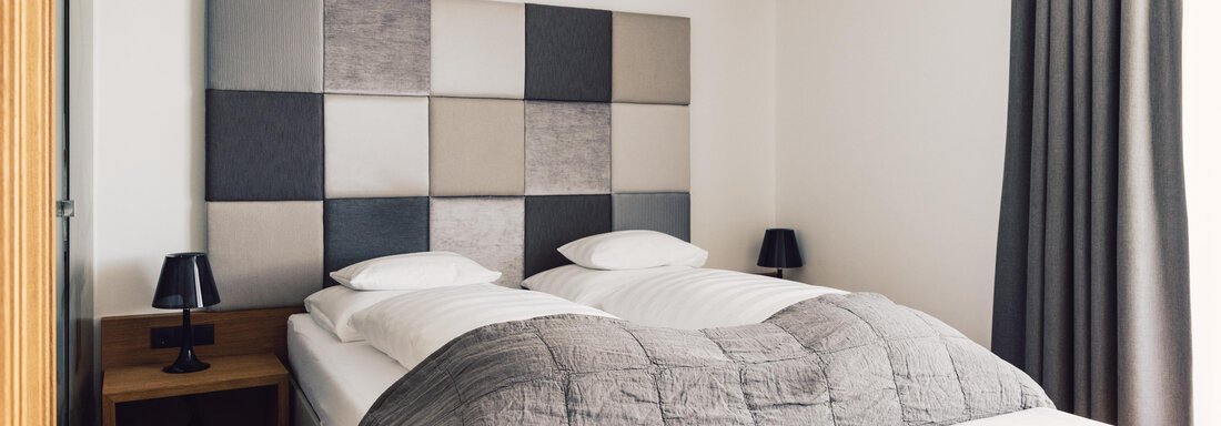schoene_aussicht_w22_danielzangerl _422 A modern bedroom with a comfortable double bed and a stylish headboard. The walls are bright and there is an elegant curtain as well as nightstands. - 4 * Superior Hotel Schöne Aussicht - Hochsölden