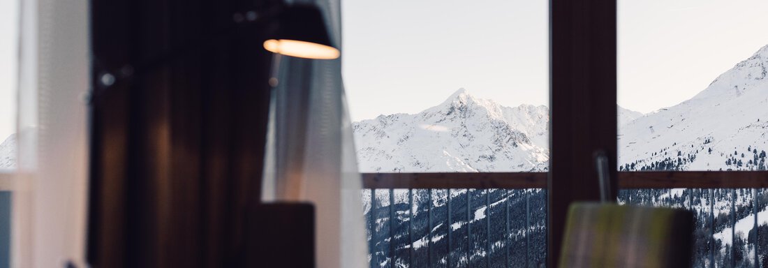 schoene_aussicht_w22_danielzangerl _578 A cozy workspace with a view of snow-covered mountains and a clear sky. The room exudes a calm and inviting atmosphere. - 4 * Superior Hotel Schöne Aussicht - Hochsölden