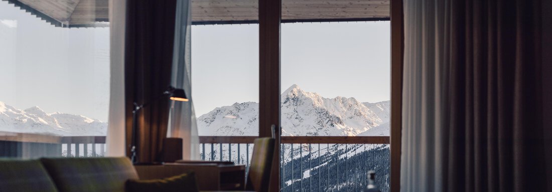 A cozy room with a view of snow-covered mountains.  
Large windows let in plenty of light and provide a relaxing atmosphere. - 4 * Superior Hotel Schöne Aussicht - Hochsölden