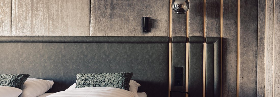 schoene_aussicht_w22_danielzangerl _475 A modern bedroom with a stylish bed and decorative pillows. The walls are adorned with an elegant, textured design. - 4 * Superior Hotel Schöne Aussicht - Hochsölden