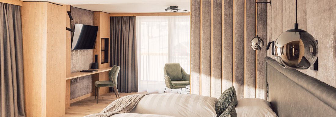 schoene_aussicht_w22_danielzangerl _386 - Kopie A modern hotel room with two beds, soft colors, and contemporary furnishings. The room features a table, a chair, and large windows for plenty of daylight. - 4 * Superior Hotel Schöne Aussicht - Hochsölden