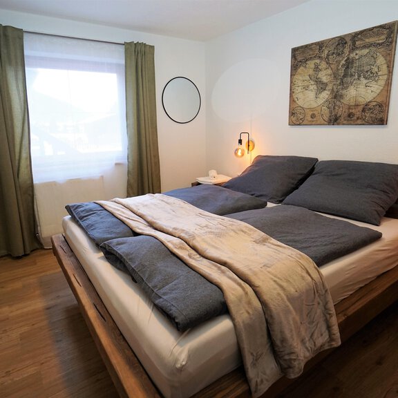 Ein gemütliches Schlafzimmer mit einem großen Doppelbett und einer Holzdecke. Sanfte Farben und natürliche Materialien schaffen eine entspannte Atmosphäre. - Apart Lisa - Huben