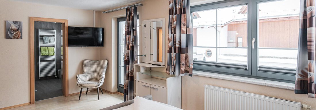 Schlafzimmer mit Doppelbett und Sessel - APART Naturcamping Kuprian - Huben