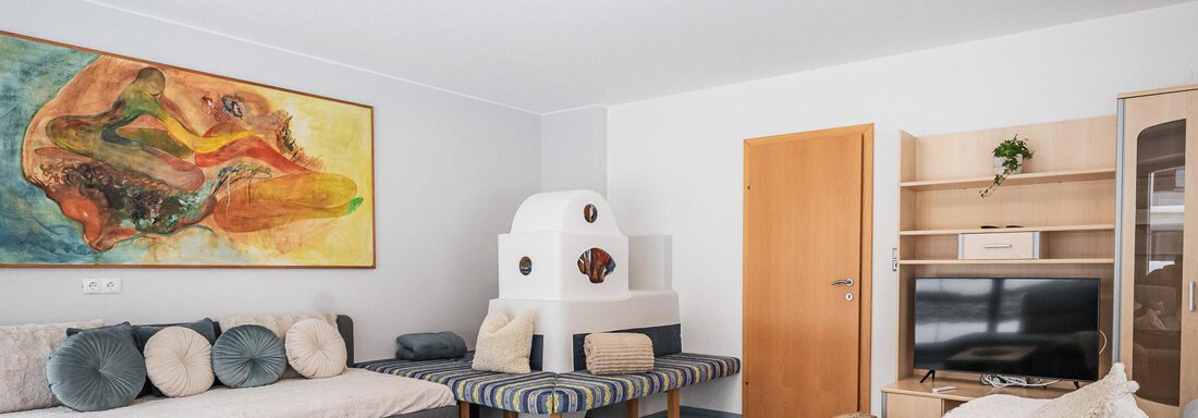 Wohnzimmer mit Blick auf den Ofen - APART Naturcamping Kuprian - Huben