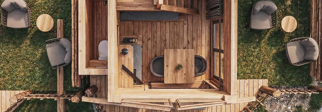 Eine hölzerne Kabine mit modernen Möbeln und einem gemütlichen Innenraum. Draußen befinden sich bequeme Sitzecken und eine schöne, natürliche Umgebung. - Naturcamping Kuprian - Ötztal - Huben