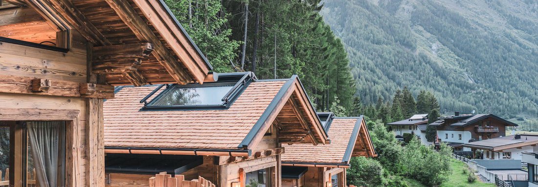 Ein malerisches Chalet im Gebirge, umgeben von Bäumen und Bergen. Die Holzarchitektur bietet eine gemütliche Atmosphäre in der Natur. - Naturcamping Kuprian - Ötztal - Huben