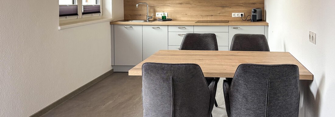 Vollausgestattete Küche | © Privat (CC C) Modern kitchen with a dining table and four chairs. The furnishings are bright and functional, with plenty of space and natural light. - 6444 Apartment - Längenfeld