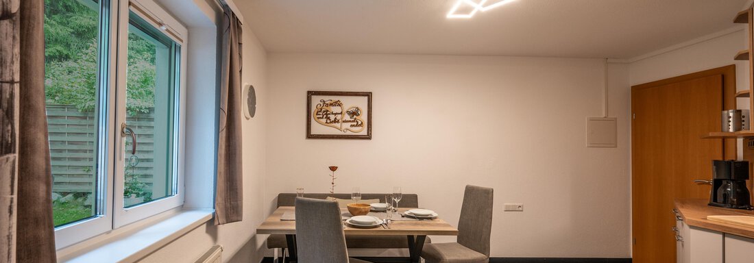 A modern dining room with a table and elegant chairs. Large windows provide plenty of daylight and a welcoming atmosphere. - Apart Conny - Längenfeld